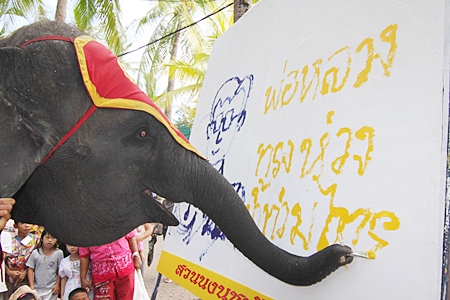 Flood evacuees look on in amazement as Yok finishes his painting of His Majesty the King.
